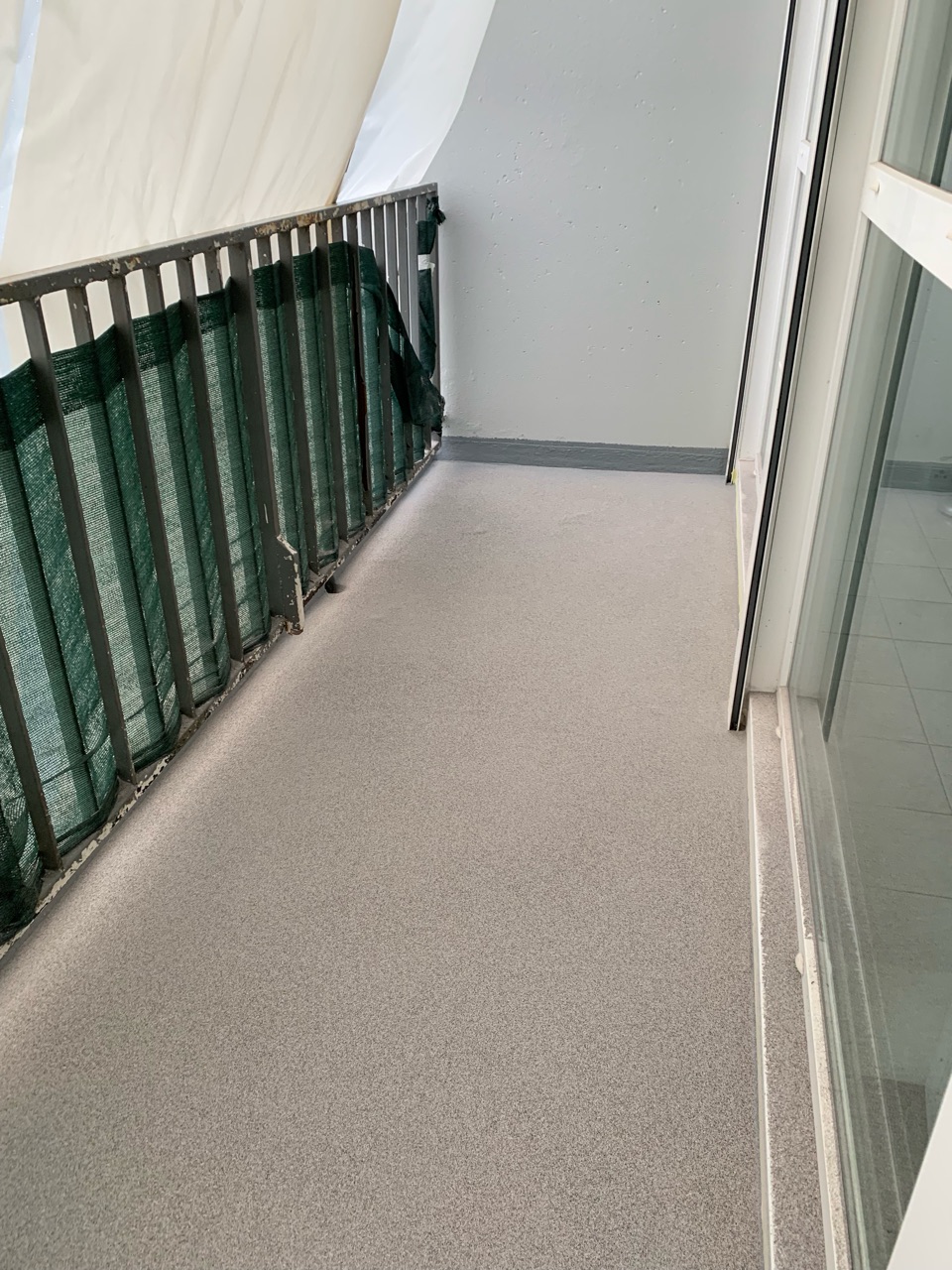 Balcon avec revêtement en résine antidérapant et étanche par Kemica Coatings, garantissant durabilité et confort avec une touche esthétique moderne pour des espaces extérieurs urbains.